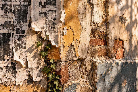 Strates d’affiches arrachées et d’enduits patinés sur un mur urbain.